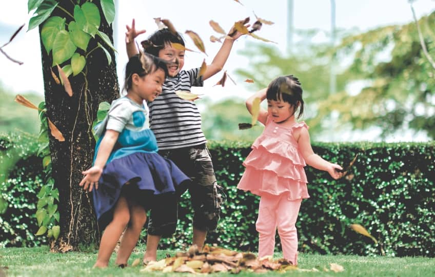 kids playing with dry leaves